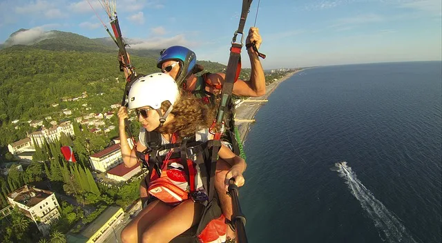 Couple paragliding over some mountains